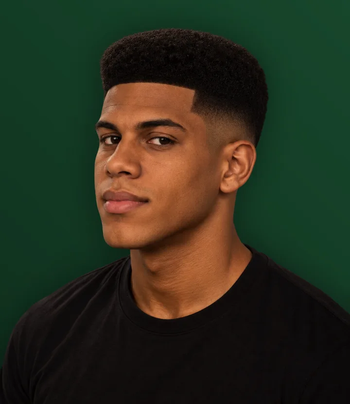 Homem de perfil com cabelo crespo curto e contorno alinhado