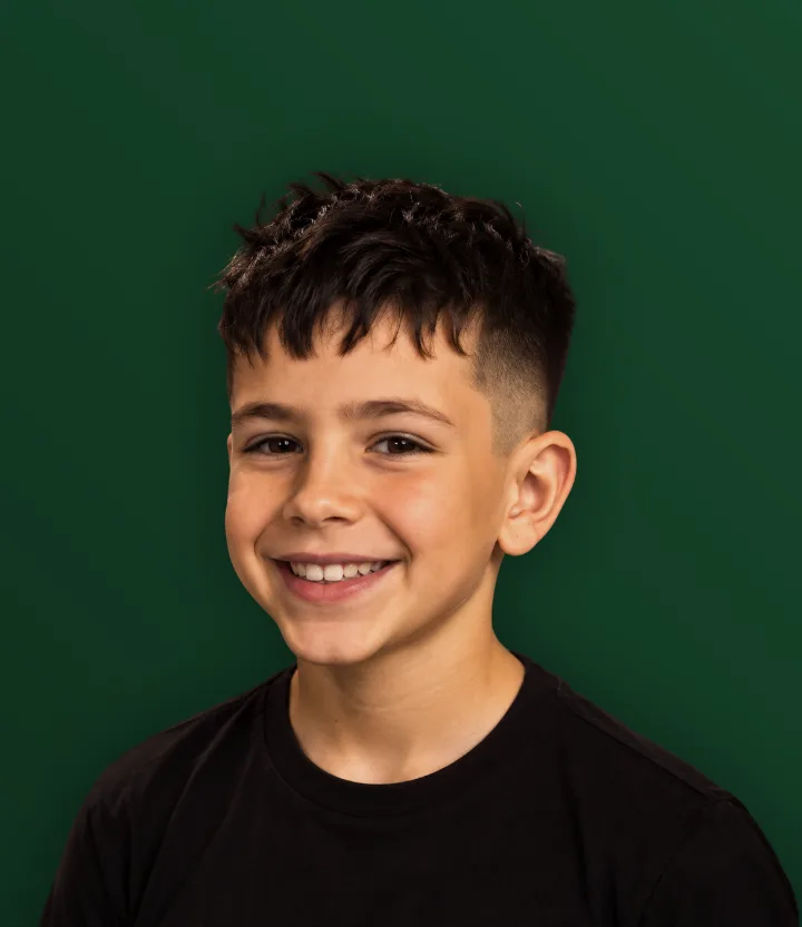 Menino sorrindo com franja curta desfiada