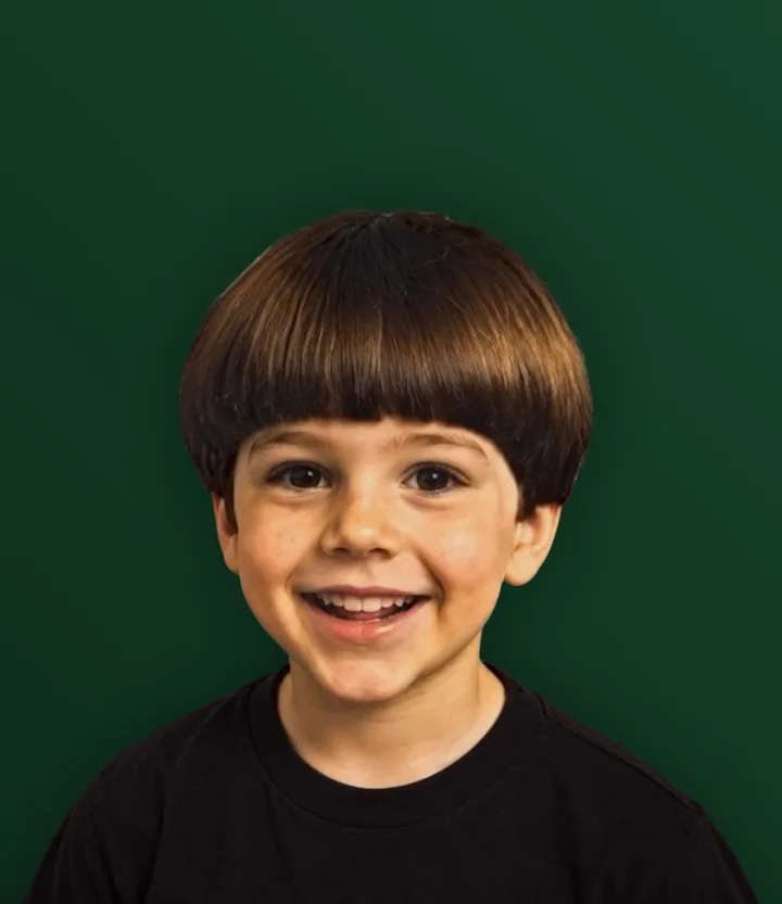 Menino sorrindo com corte tigelinha e franja reta
