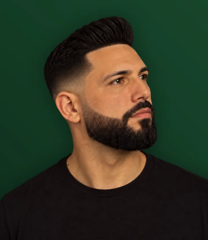 Homem de perfil com mid fade e barba cheia